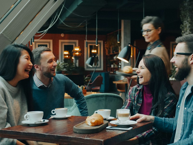 Friends laughing over coffee at a cafe